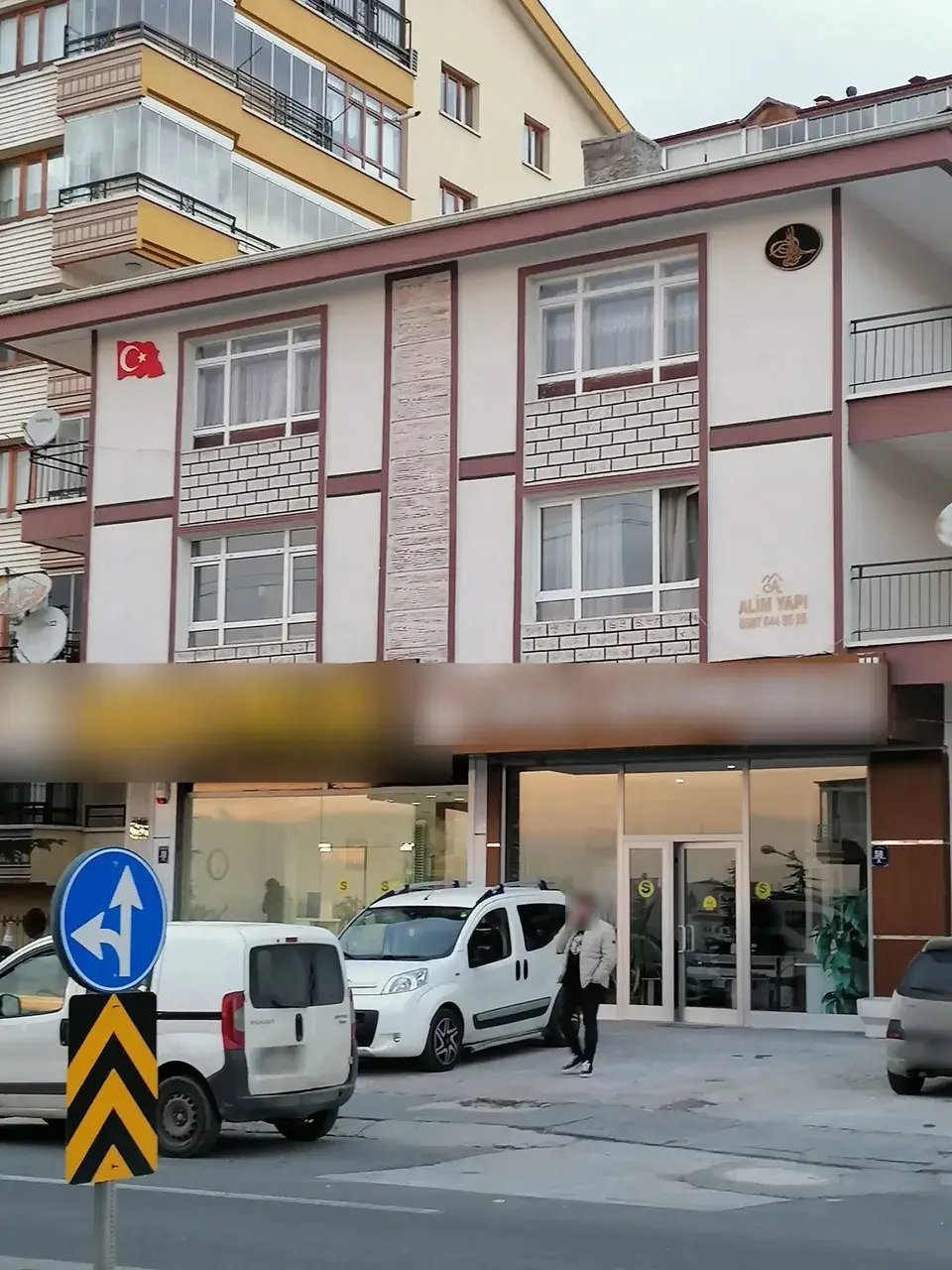 Cephede tuğla desenli paneller, taş şerit ve Alim Yapı levhası, yakın plan